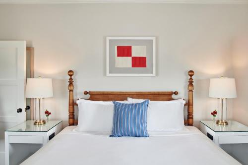 a bedroom with a large white bed with two lamps at Harbor View Hotel in Edgartown