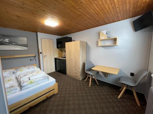 1 dormitorio con cama, escritorio y mesa en Apartments Maxi en Strážné