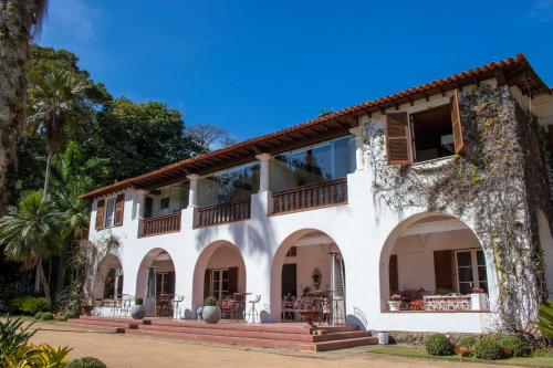 a large white building with a balcony at Locanda Bela Vista in Itaipava