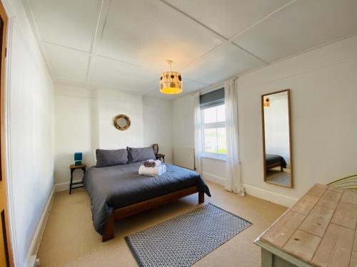 a bedroom with a bed with a stuffed animal on it at Driftwood Cottage in Bude