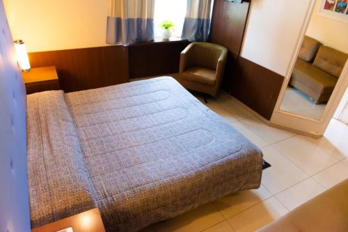 a bedroom with a bed and a chair in a room at Villa Verde Hotel in Avaré