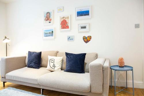 a living room with a couch and pictures on the wall at Bright Chelsea Garden Nest in London