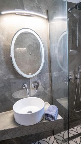 a bathroom with a white sink and a mirror at Mythic Villas in Epanomi
