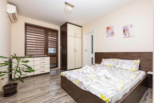- une chambre avec un grand lit et une plante dans l'établissement 1BD Flat with a lovely terrace in the centre of Plovdiv, à Plovdiv