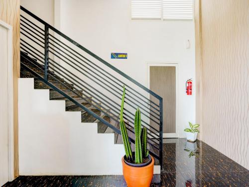 a hallway with a staircase and a potted plant at LG Hotel Jember in Berpodak