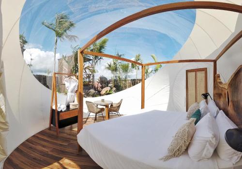 ein Schlafzimmer mit einem Bett und einem Tisch in einem Zimmer in der Unterkunft Green Land Bubble Glamping in Cabarete