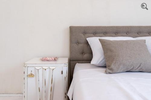 a bedroom with a white bed and a white night stand at Wine house apartment in Karaburma