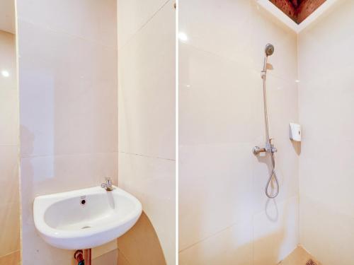 a white bathroom with a sink and a shower at LG Hotel Jember in Berpodak