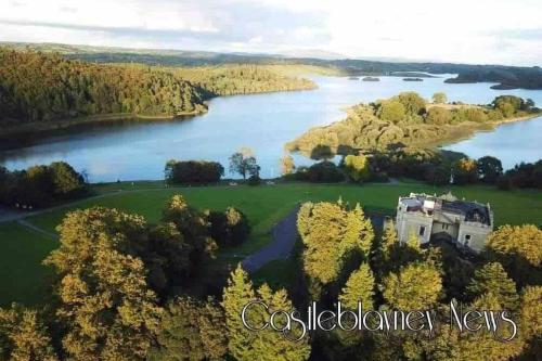 an aerial view of a house on a hill next to a lake at Glenmount Castleblayney in Castleblayney