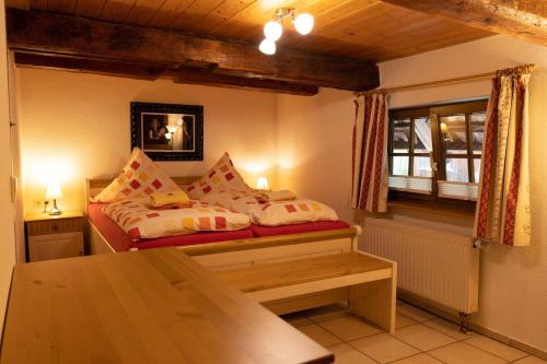 um quarto com uma cama, uma mesa e uma janela em Ferienhof-Gerda-Ferienwohnung-Storchennest em Oberkirnach