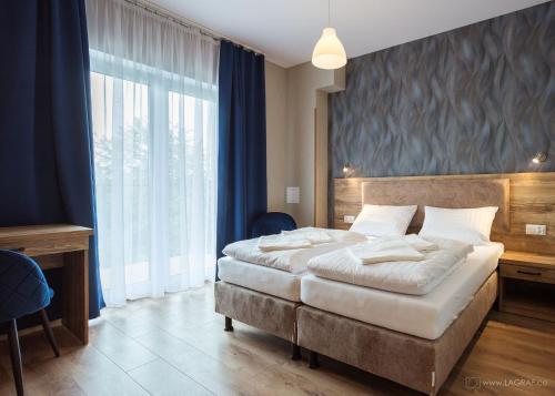 a bedroom with two beds and a large window at Origami Prestige in Koszalin
