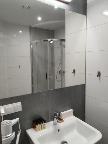 a bathroom with a sink and a shower at Hotel Garbów *** Centrum Konferencyjno - Bankietowe in Garbów