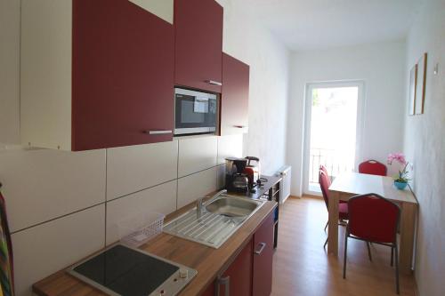 eine Küche mit einem Waschbecken und einem Tisch mit Stühlen in der Unterkunft Pension Budissin in Bautzen