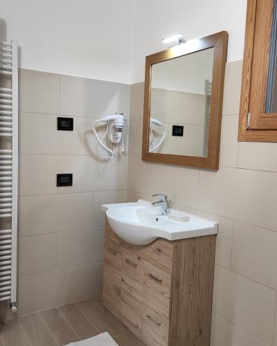 a bathroom with a sink and a mirror at Orobie Holiday Apartments in Albosaggia
