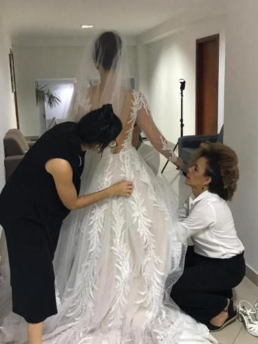 two women helping a bride in her wedding dress at Hotel Skalla - MELHOR CUSTO BENEFICIO in Teixeira de Freitas