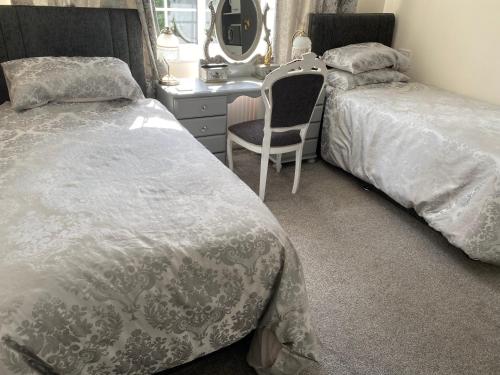 1 dormitorio con 2 camas, escritorio y silla en Tower Hill House Basingstoke, en Basingstoke