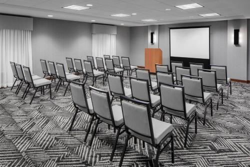 a room with a bunch of chairs and a screen at Hyatt Place Boston/Braintree in Braintree
