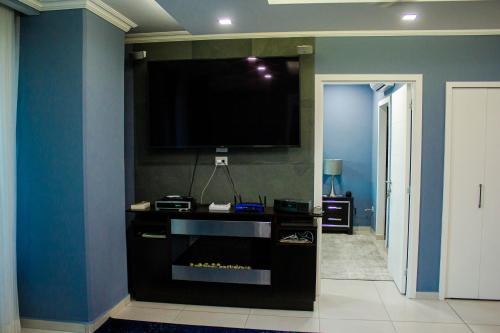 a living room with a flat screen tv on a wall at JF Three Bedroom Apartment in Tegucigalpa