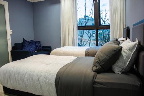 特古西加尔巴JF Three Bedroom Apartment的一间卧室设有两张床、一张沙发和一个窗口
