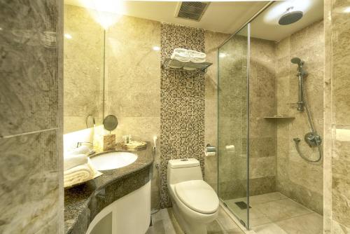 a bathroom with a toilet and a sink and a shower at RC Hotel Melaka in Melaka
