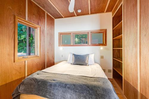 a small bedroom with a bed and two windows at Sound View in South Beach