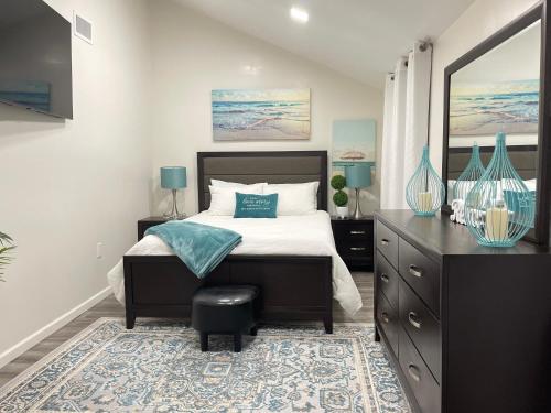 a bedroom with a large bed with a dresser and a mirror at Water Canal Villa Salgado in Bellmore