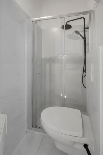 a white bathroom with a shower and a toilet at Small Design Studio - Rosa, Bairro Alto in Lisbon