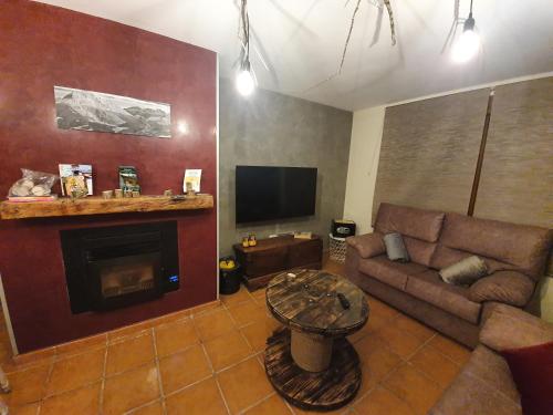 a living room with a couch and a fireplace at LA LEYENDA DEL CURAVACAS in Alba de los Cardaños
