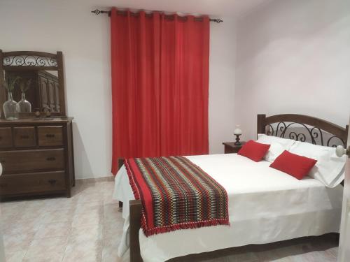 una camera con letto e tenda rossa di AL Colmeia de Mel a Reguengos de Monsaraz