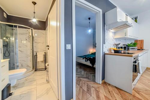 a bathroom with a shower and a toilet and a sink at Apartamenty Świętokrzyska in Leszno