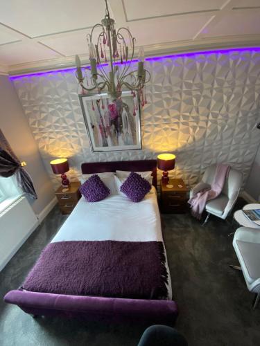 a bedroom with a large bed with purple pillows at Ashmira Guest House in Weymouth