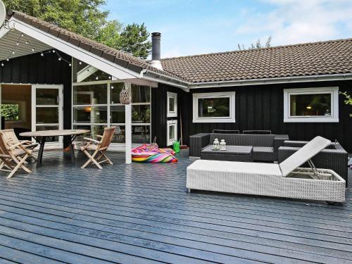 una terrazza con divano e sedie su una casa di 8 person holiday home in Vejby a Vejby