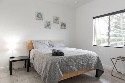 a bedroom with a bed with two pairs of shoes on it at New house on the block near Miami Airport. in Miami