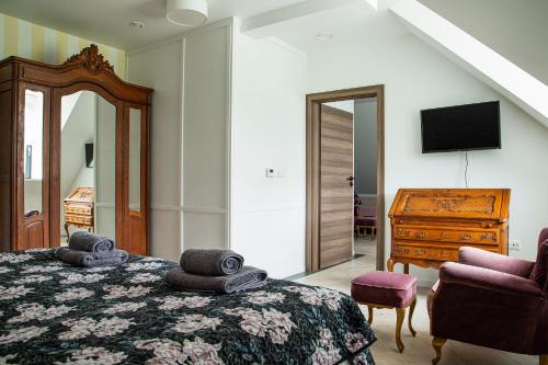 a bedroom with a bed and a dresser and a mirror at Czarna Dama Apartamenty in Janowiec