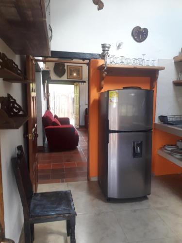 cocina con nevera y silla en una habitación en Refugio Villa Tere, en Villa de Leyva
