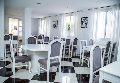 een eetkamer met een witte tafel en stoelen bij Sorrento Hotel Boutique in Trenque Lauquen