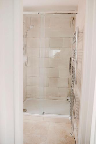 a shower with a glass door in a bathroom at 1 Chantry Cottage in Tunstall