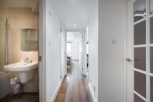 a white bathroom with a sink and a mirror at Views For Days - Fitzrovia - by Frankie Says in London