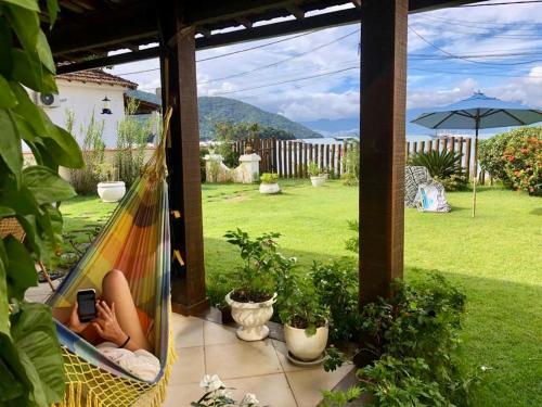 a person laying in a hammock on a patio at Aretê Ilha Grande in Abraão