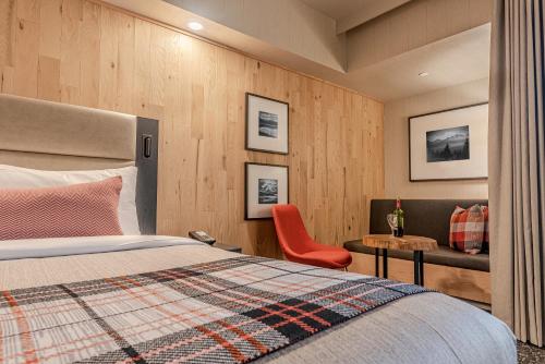 バンフにあるPeaks Hotel and Suitesのベッドとテーブルと椅子のある寝室