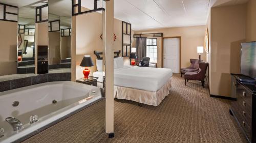 um quarto de hotel com uma cama grande e uma banheira em Best Western Galena Inn & Suites em Galena