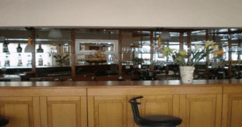 a bar with a black chair sitting at a counter at Filareti Hotel in Florina