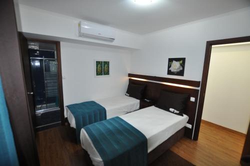 ラジェス・ド・ピコにあるCasa da Abróteaのベッド2台と鏡が備わるホテルルームです。
