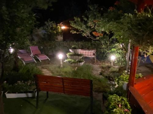 a park bench in a garden at night at Apartments and bungalows vila Dalibor in Nin