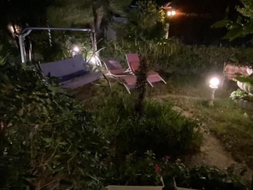 a garden at night with a table and chairs at Apartments and bungalows vila Dalibor in Nin