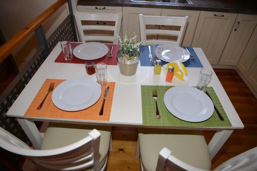 a table with white plates and utensils on it at Dio Guesthouses in Leonidion