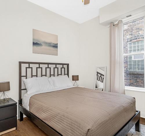 Un dormitorio con una cama grande y una ventana en Spacious 5-BR Apt next to transit Free Parking en Chicago