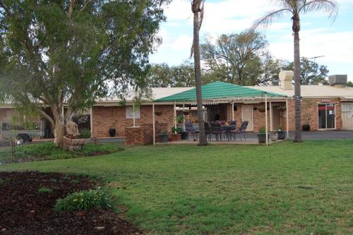 a house with a green roof and a yard at Charleville Waltzing Matilda Motor Inn in Charleville