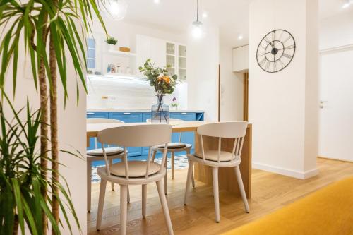 kuchnia ze stołem, krzesłami i zegarem w obiekcie Akiton Apartment w Belgradzie
