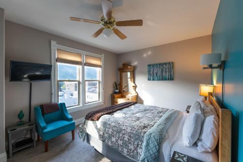 a bedroom with a bed and a blue chair at Cloudside Hotel in Nelson